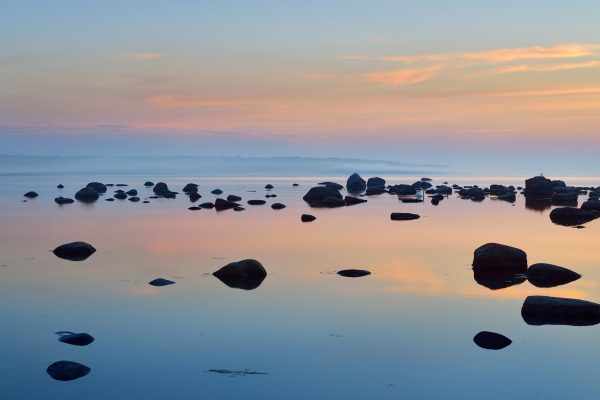 Calm waters and dark rocks at sunset