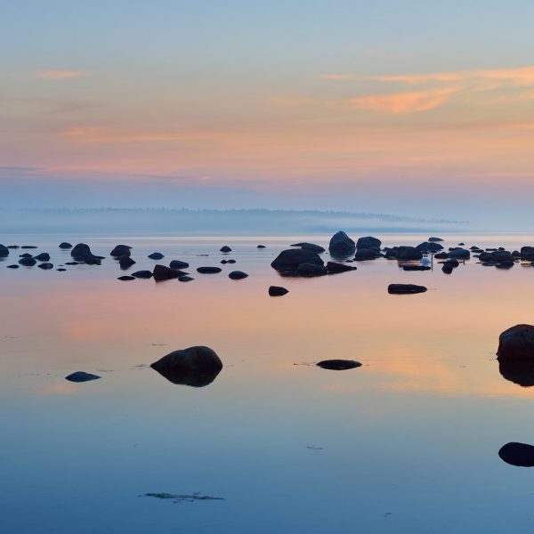 Calm waters and dark rocks at sunset